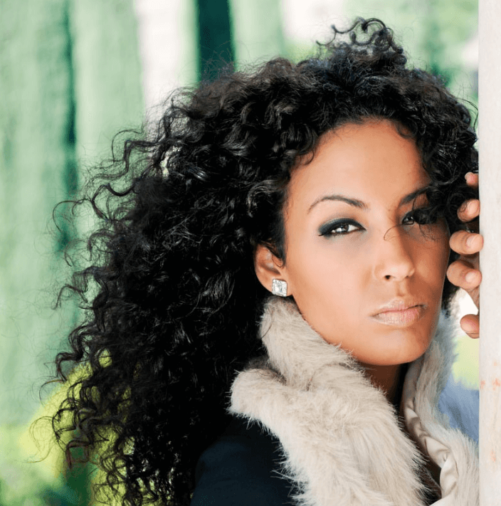 Femmes avec un maquillage noir et des cheveux bouclés, mettant en valeur le Mascara rehausseur du regard.